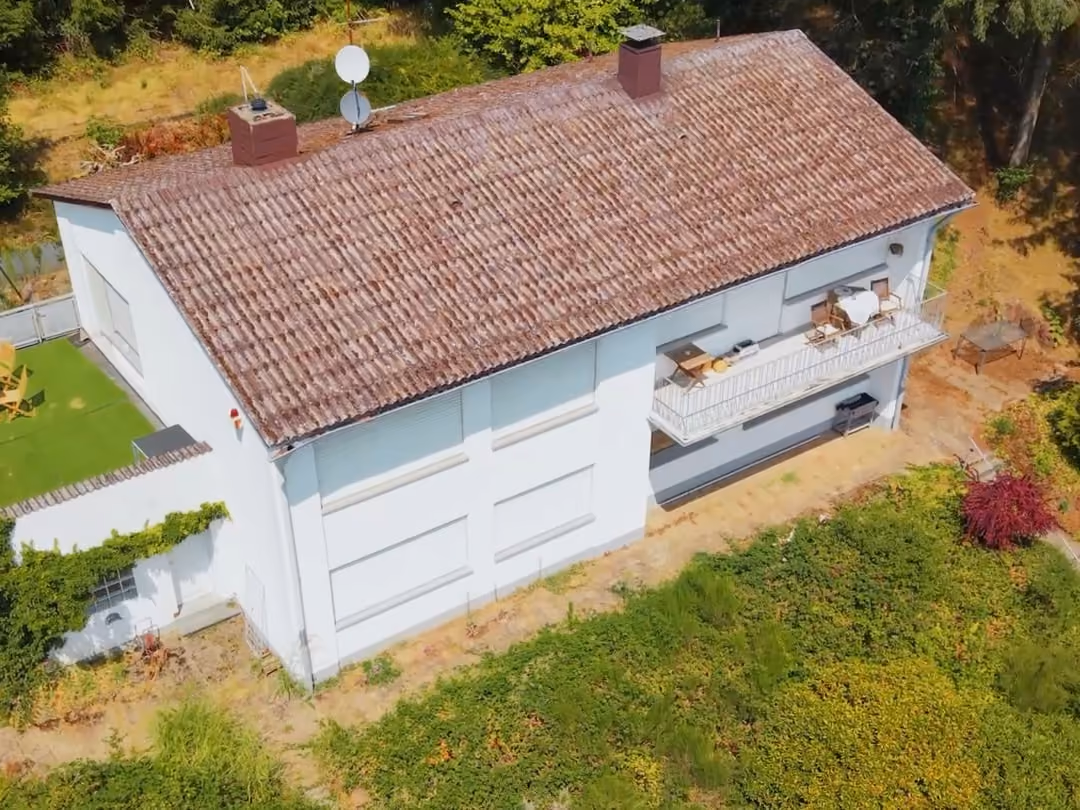 Drohnenfoto eines Bungalows mit Garten und Grundstück schräg von oben