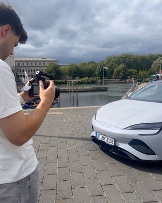 Max filmt ein weißes Auto am Wasser